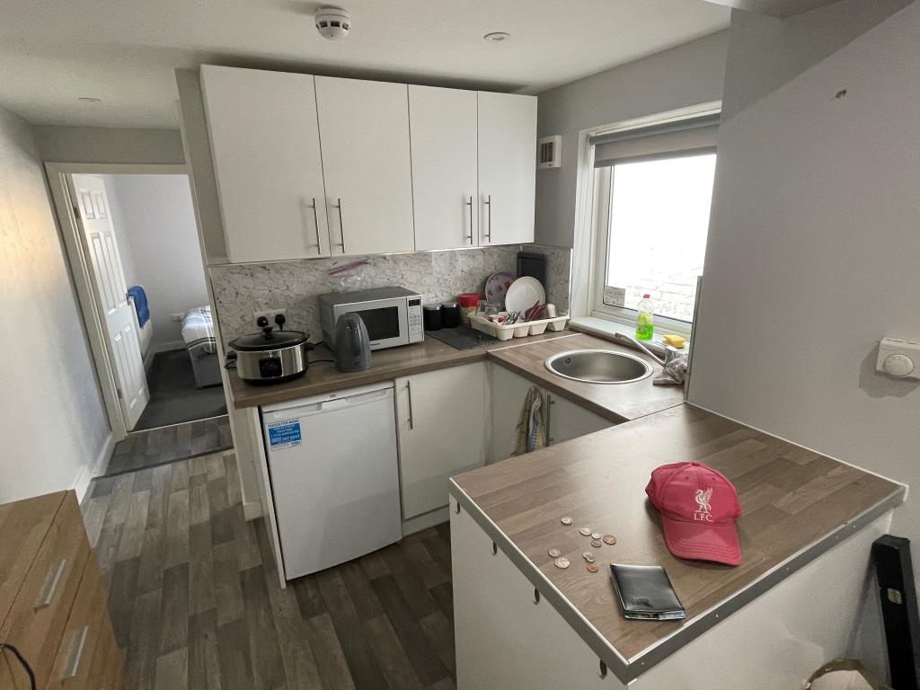 Lot: 133 - FOUR WELL-PRESENTED LETTING UNITS WITH POTENTIAL FOR A FIFTH UNIT - Kitchen leading through to bedroom